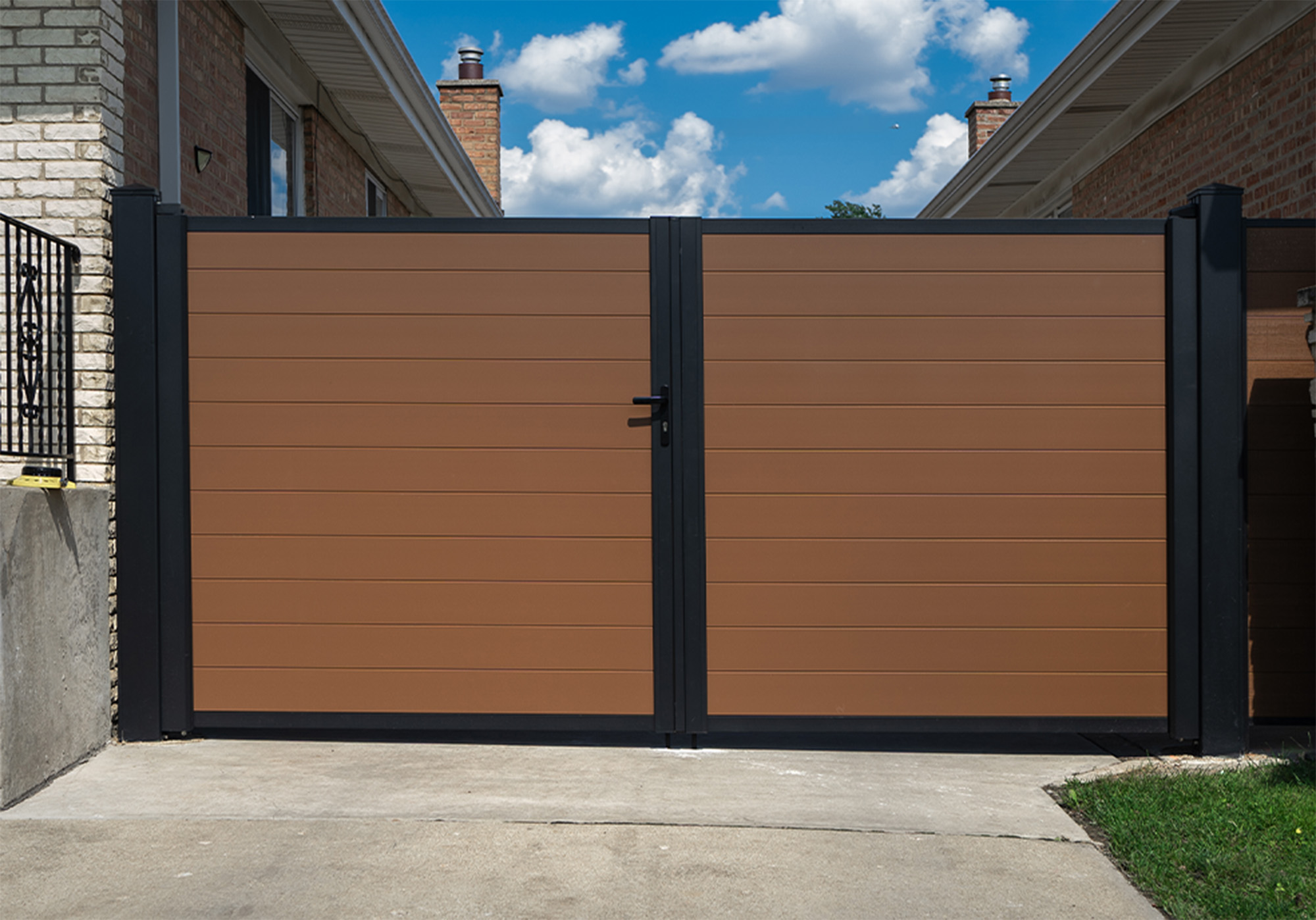 Greenwood Fence wide-span aluminum double driveway gate with Matte Black frame and Cedar-finish aluminum infill
