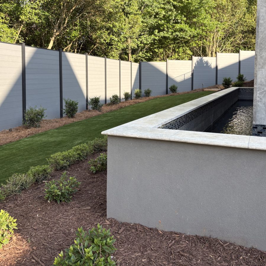 Greenwood Fence Elite Privacy composite fence in Storm Grey on 100x100mm HP posts above a landscaped retaining wall