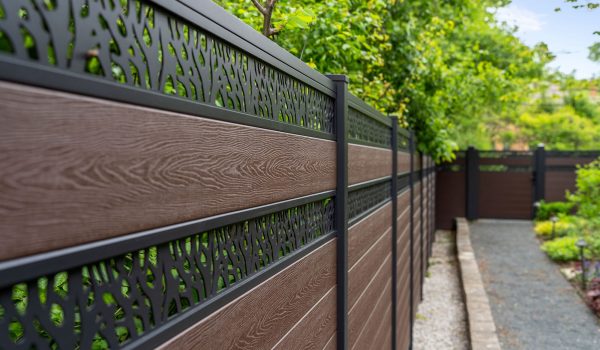 GWF® Double Ornamental Lattice composite fence run in Aspen Brown along a garden path, low angle showing woodgrain infill and aluminum lattice topper bands