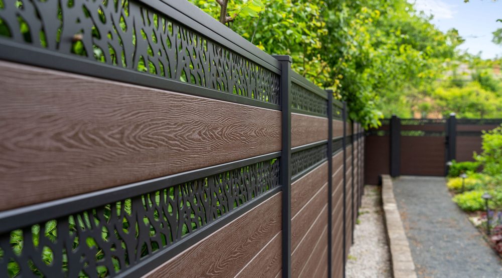 GWF® Double Ornamental Lattice composite fence run in Aspen Brown along a garden path, low angle showing woodgrain infill and aluminum lattice topper bands