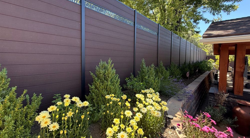 Greenwood Fence Single Ornamental Lattice composite fence in Aspen Brown, a garden